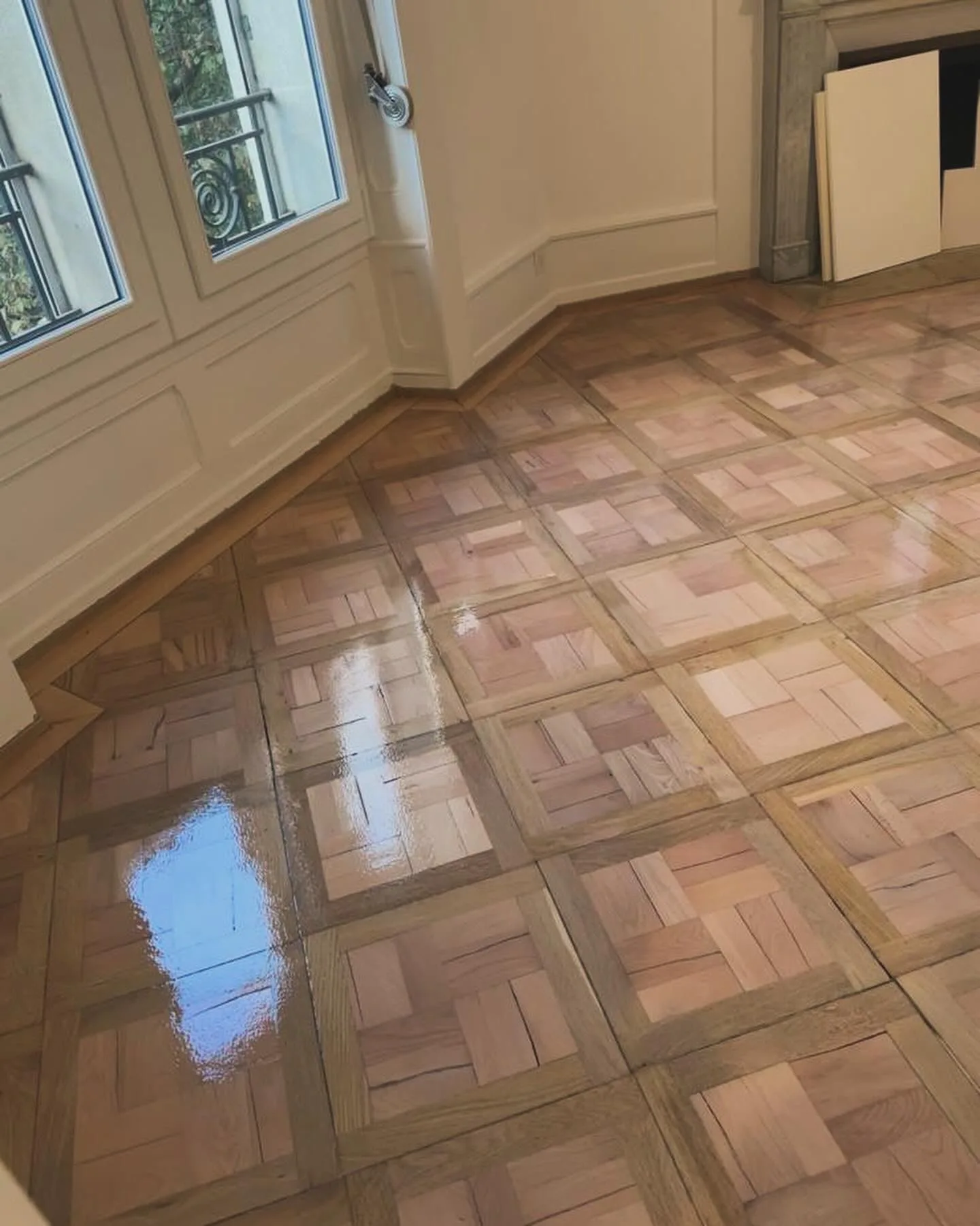 Parquet mosaïque vitrifié et brillant devant une fenêtre